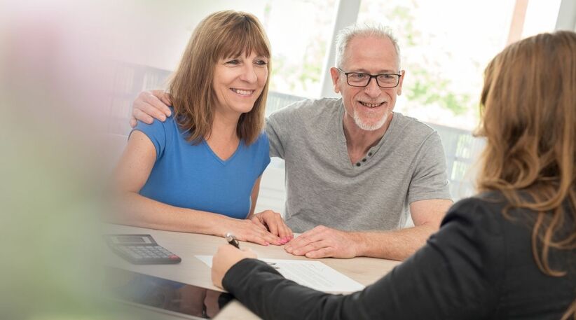 Un couple souriant face à un conseiller expliquant le nouveau dispositif PER plan d'épargne retraite