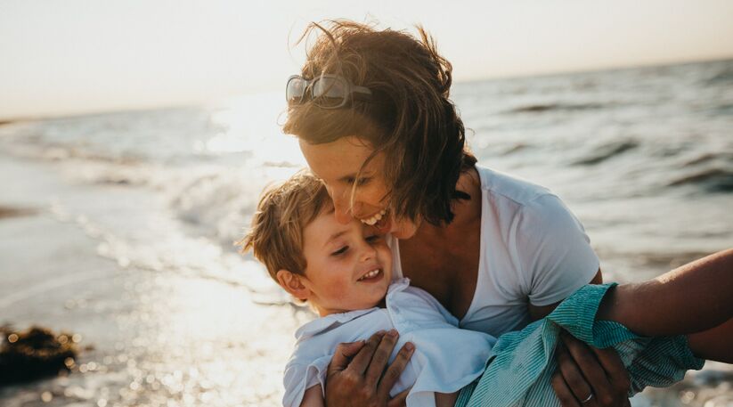 La solution Préfon Vie Responsable : une mère porte son enfant dans les bras devant la mer